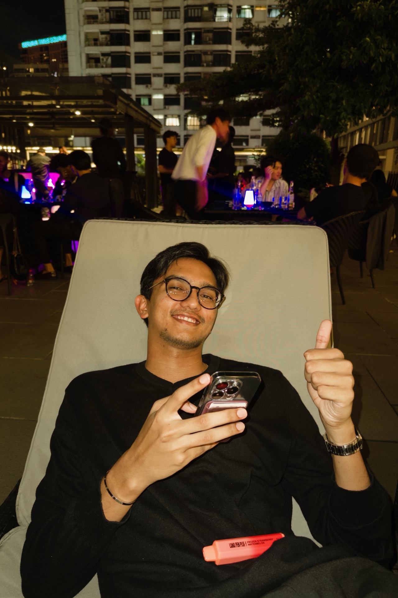 Devam on a KL rooftop at night, thumbs up